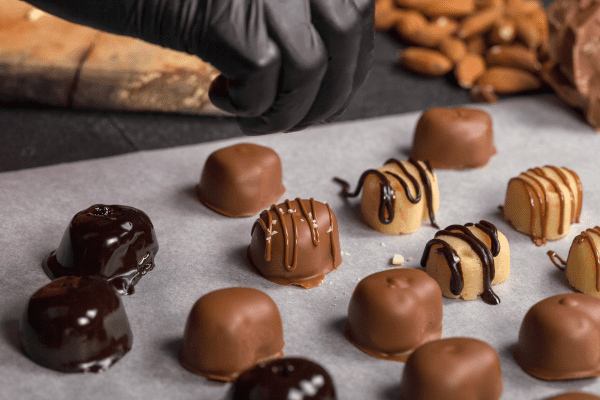 Confectioner creating chocolates. Reduce - Sugar - Salt - Food Manufacturer Solutions